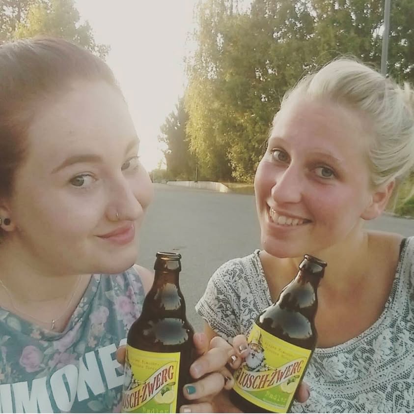 Zwei Frauen halten Lösch-Zwerg Flaschen in den Händen und lächeln