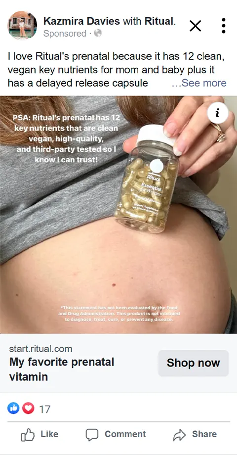 Pregnant person holding Ritual prenatal vitamin bottle by bare belly wearing gray shirt.