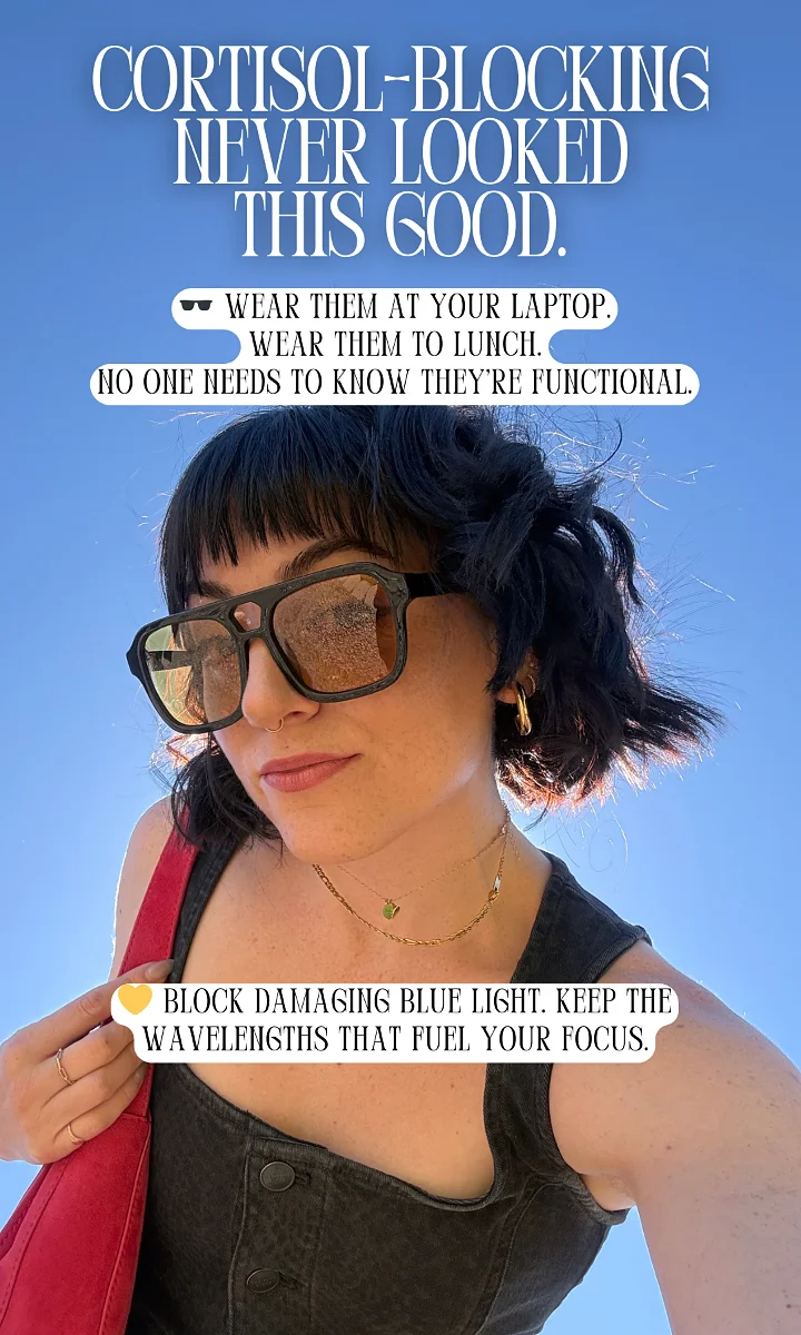 Woman wearing large sunglasses under blue sky, promoting cortisol-blocking glasses to block damaging blue light.