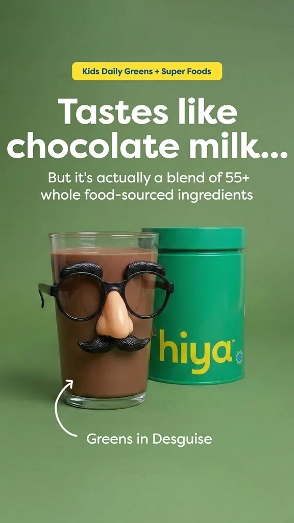Glass of chocolate milk wearing disguise glasses, nose, and mustache, with Hiya greens container behind it.