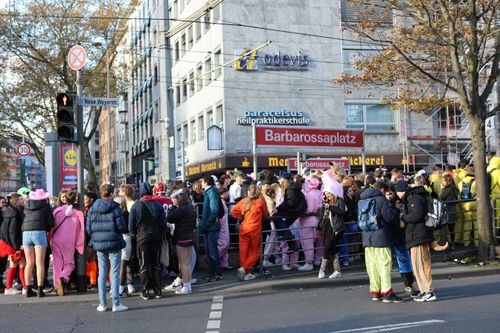 Feiernde Menschen stehen an der Haltestelle Barbarossaplatz.