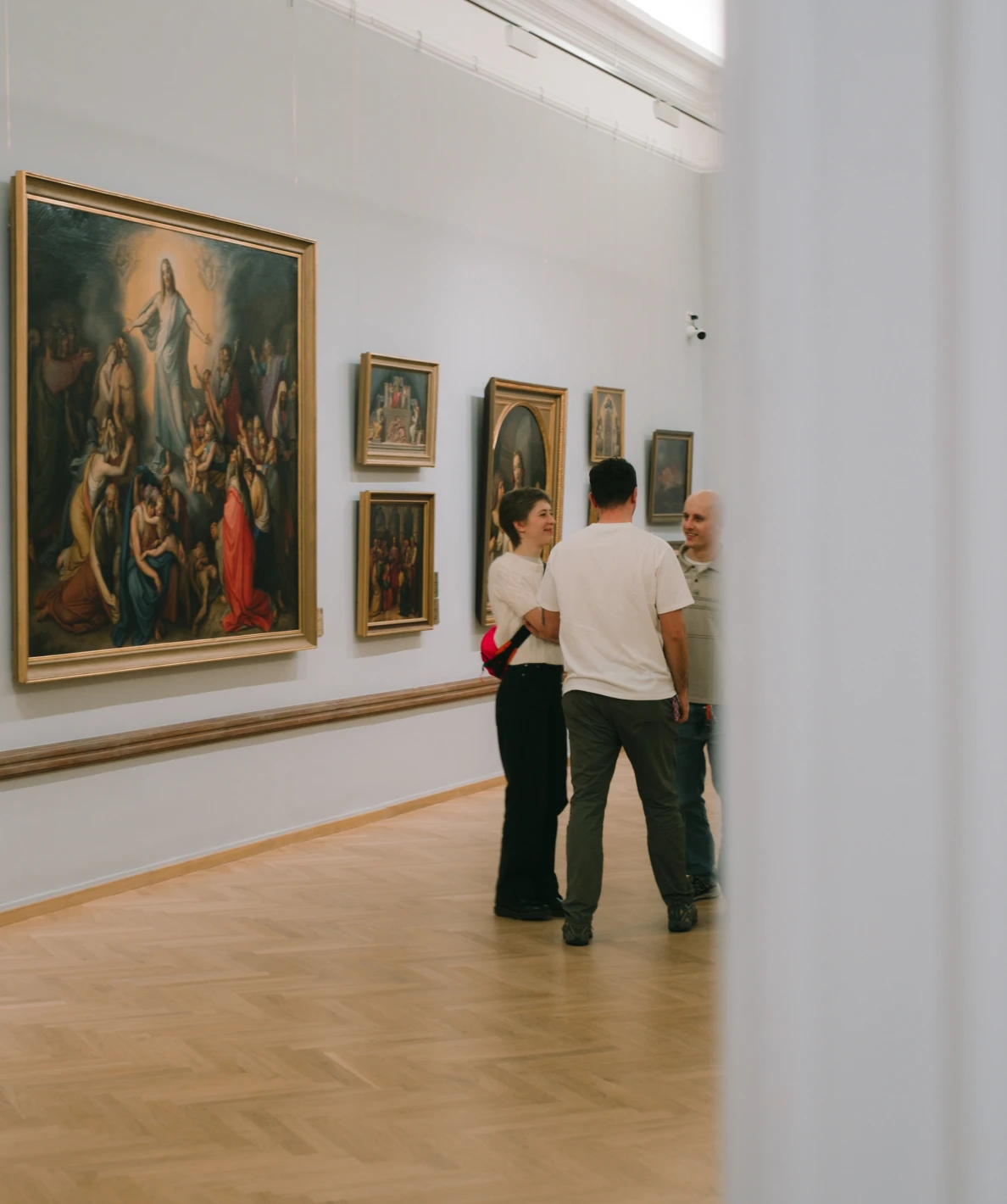 Zwiedzający rozmawiają w sali Galerii Sztuki Europejskiej