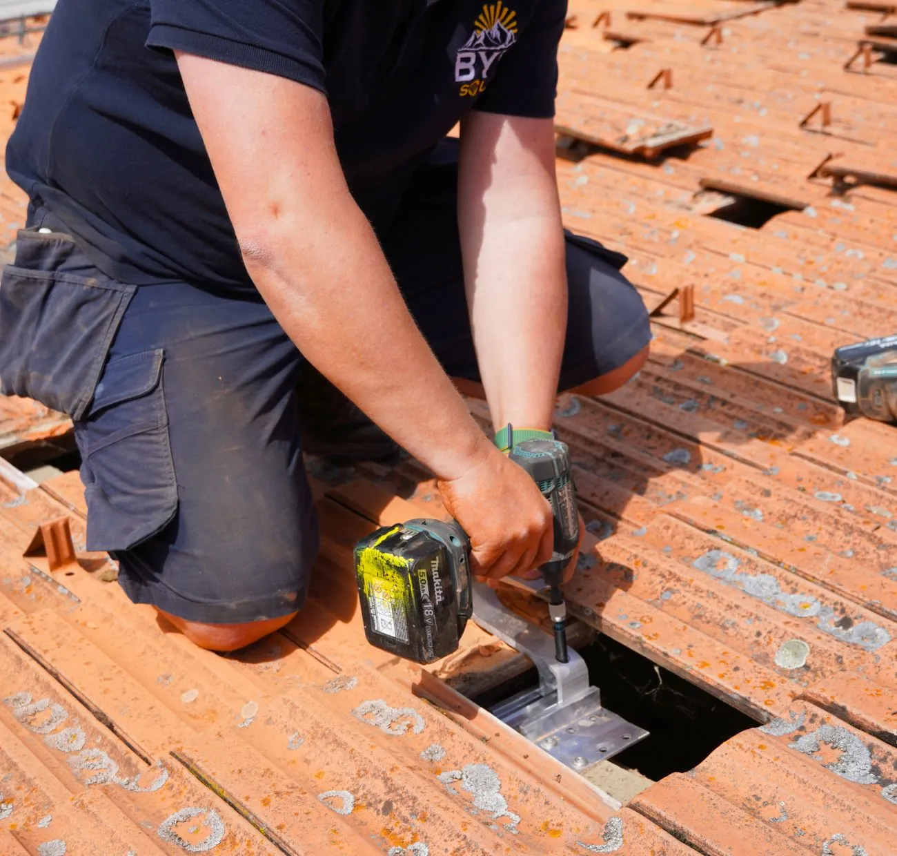 Solar worker screwing photovoltaic panel