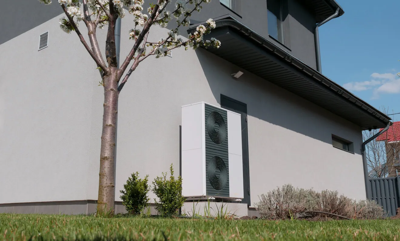 Ein Handwerker in orangefarbenem BYM Solar Poloshirt montiert eine Aluminiumhalterung auf einem Ziegeldach.