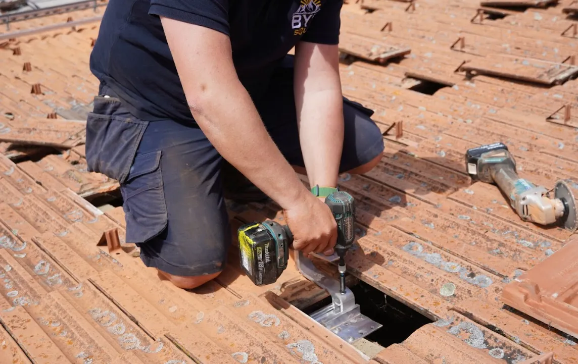solar installer screwing solar bade module