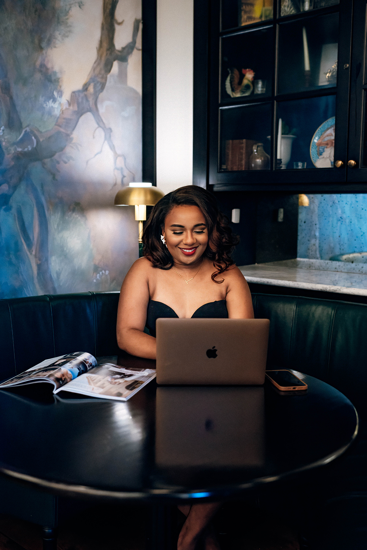 Jacinda Merchant owner of J'Adore Bridal, branding portraits at La Belle Helene in Charlotte, NC. Typing on laptop in booth.