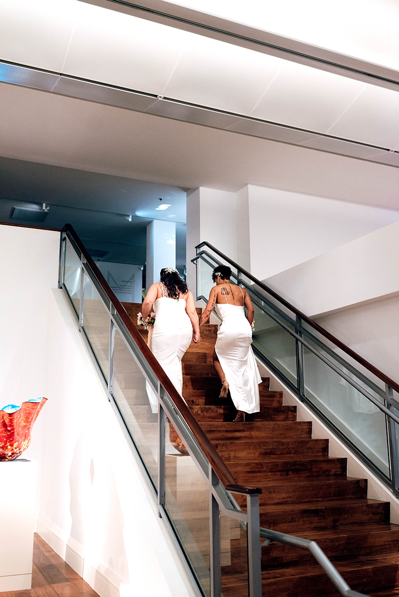 Wedding styled shoot at 220 North Tryon in Charlotte, NC and Foundation of the Carolinas art gallery. Couple walking up stairs to second floor of art gallery.