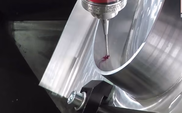 Close-up of a precision probe measuring the inside surface of a curved metallic machined part.