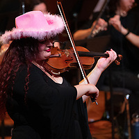 Georgia soloing with an orchestra with a pink cowboy hat on.