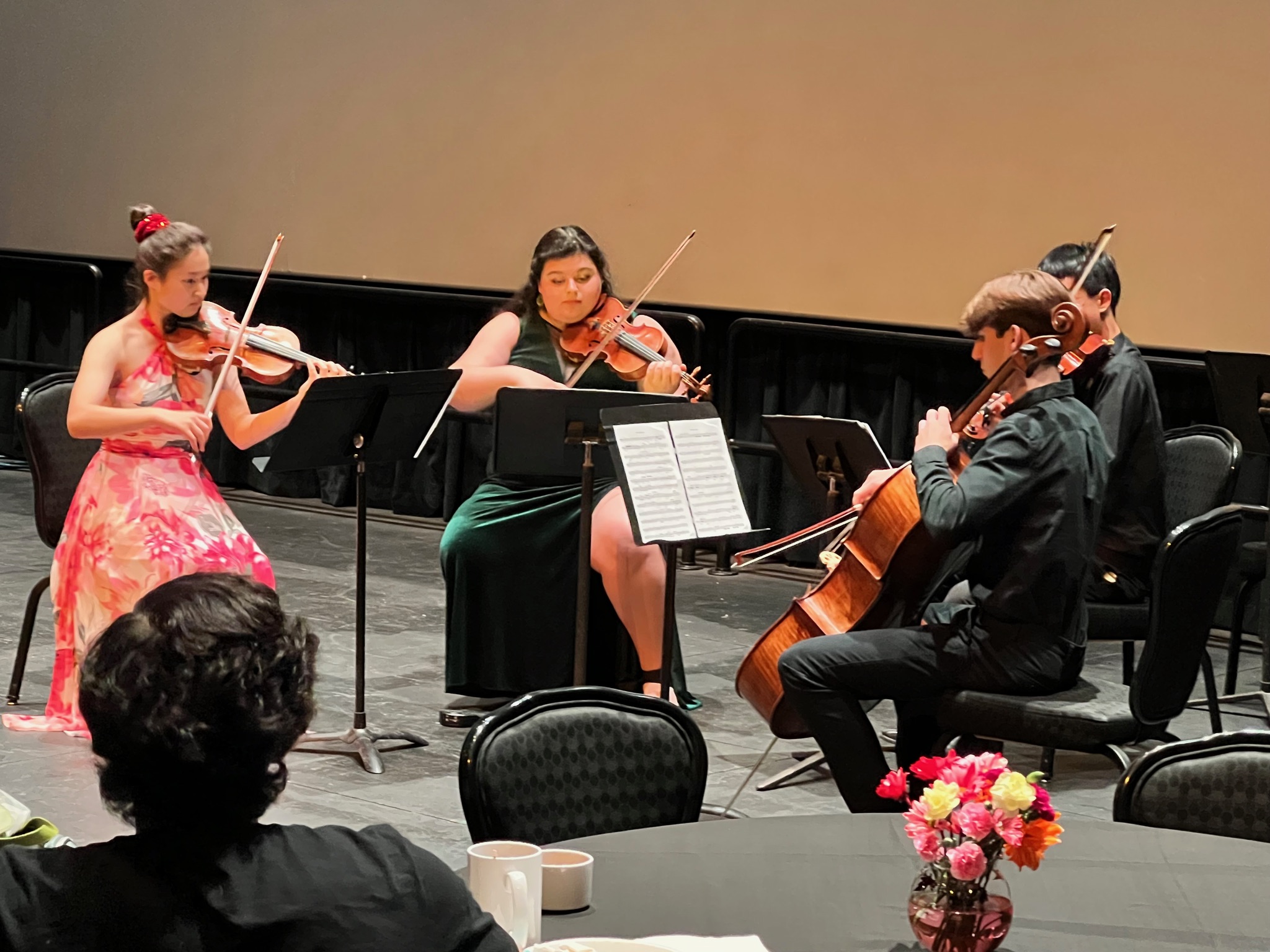 Georgia and her friend, Faith, playing in their quartet. Georgia is in a velvet green dress and Faith is wearing a pink and white flora dress.
