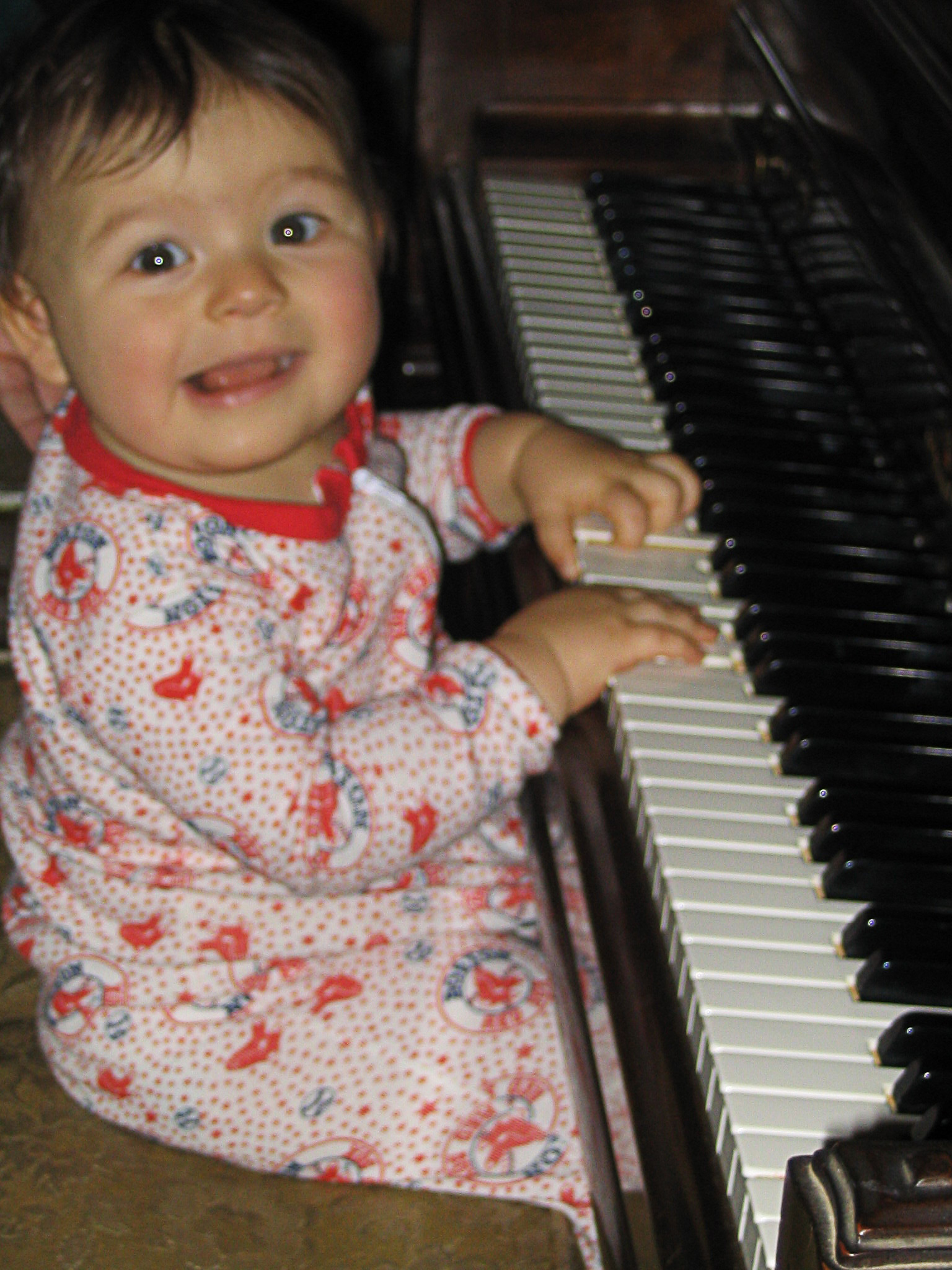 Georgia at 2 years old sitting at the piano.
