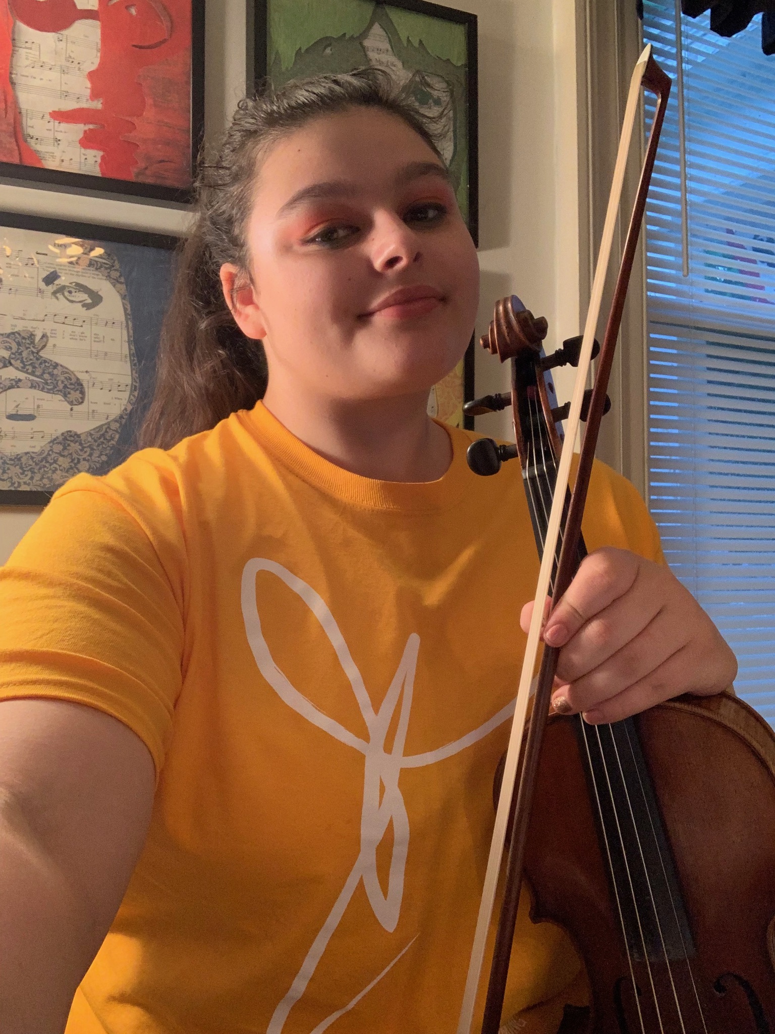 Georgia in a yellow shirt and her violin.