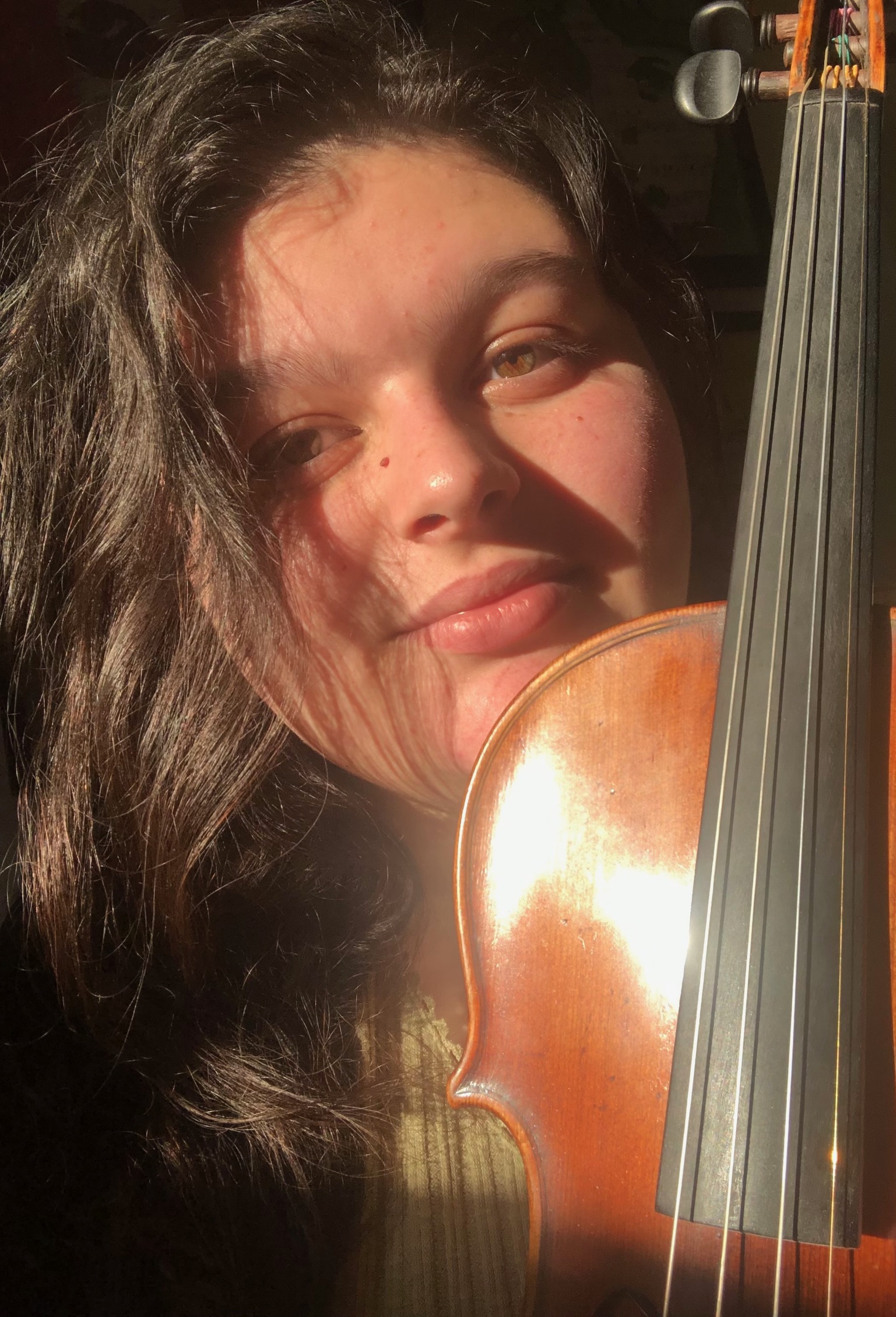 Georgia in a green sweater with her violin.