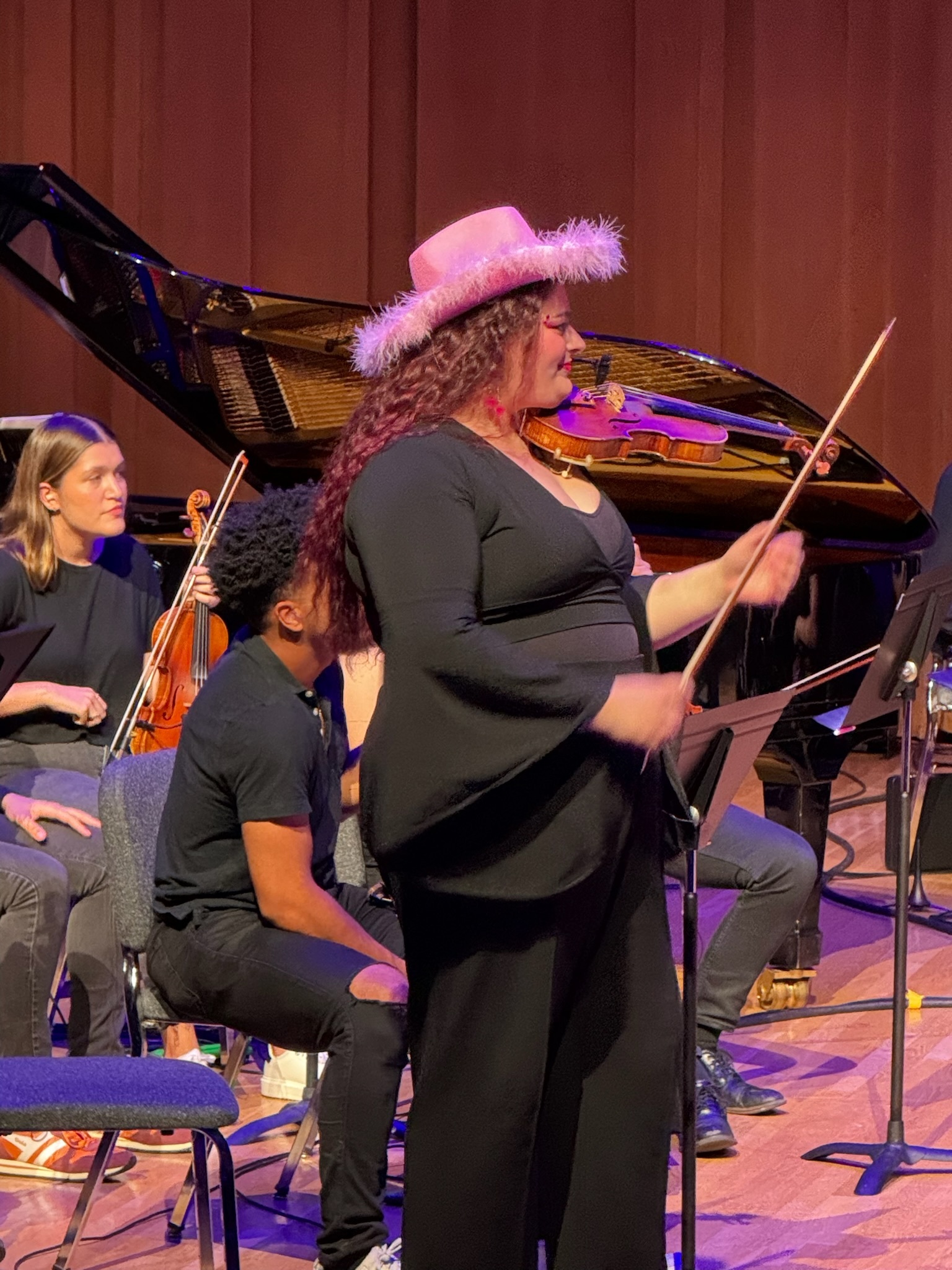 Georgia with a pink cowboy hat soloing with an orchestra.
