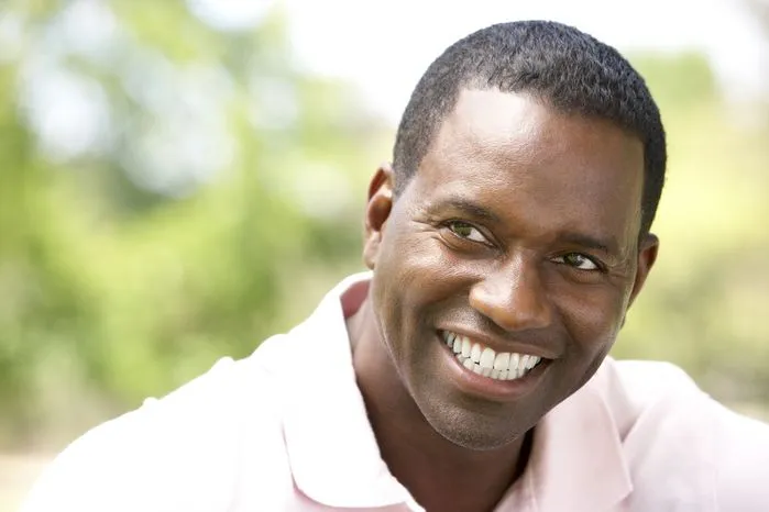 A view of a happy man smiling in the sunshine—learn how to be positive, think positive, and shift your mindset for a better life.