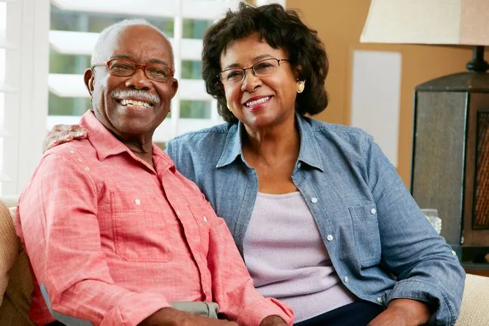 An image of a smiling older couple sitting together at home.