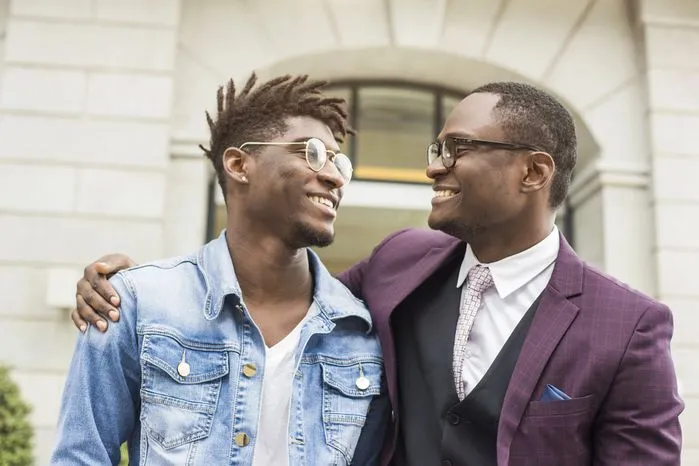 An image of two men sharing a moment of encouragement and strength with smiles and support