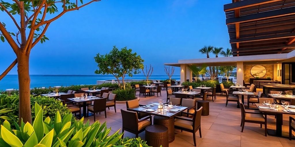 Área de comedor al aire libre en Nobu Cabo con vegetación exuberante.