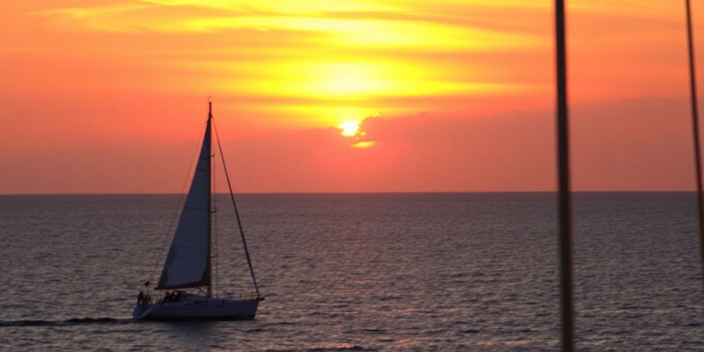 Cabo San Lucas sunset with sailboats on the horizon.