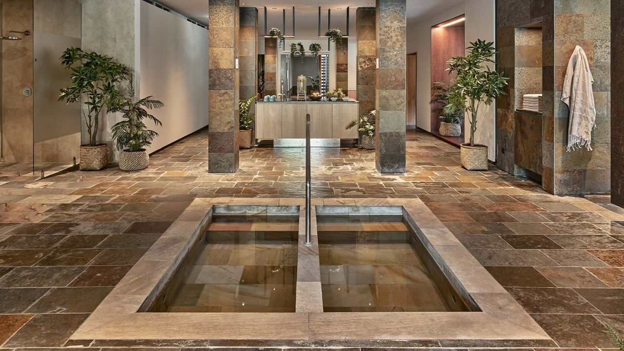 Área de spa com piso de pedra e banheiras no Acquapura SPA