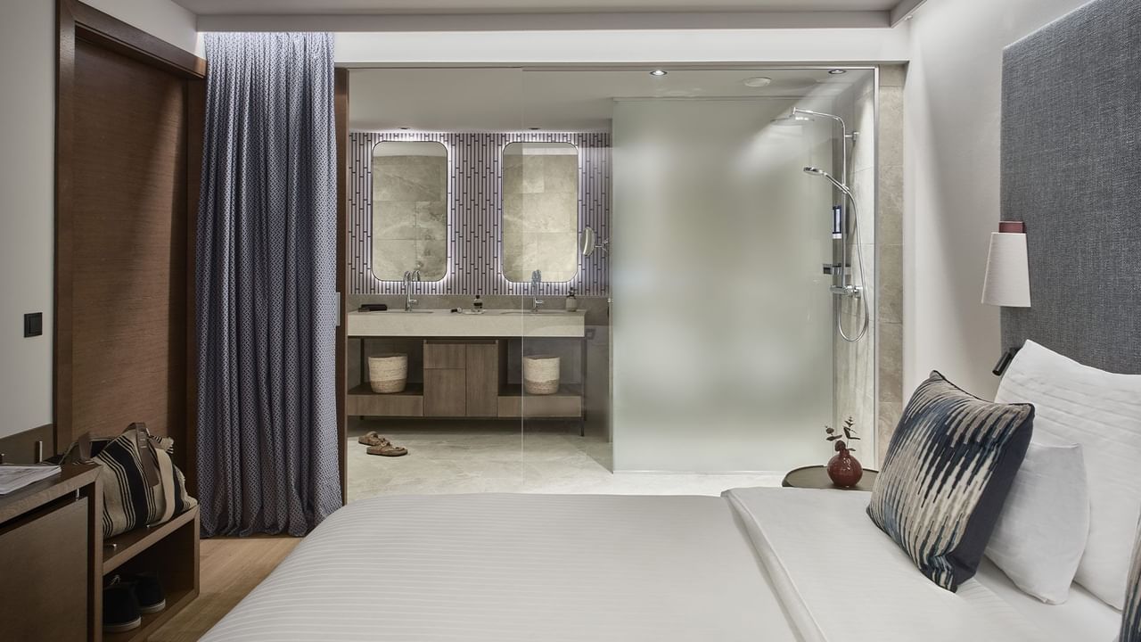 Cama com banheiro de vidro na Carnica Suite