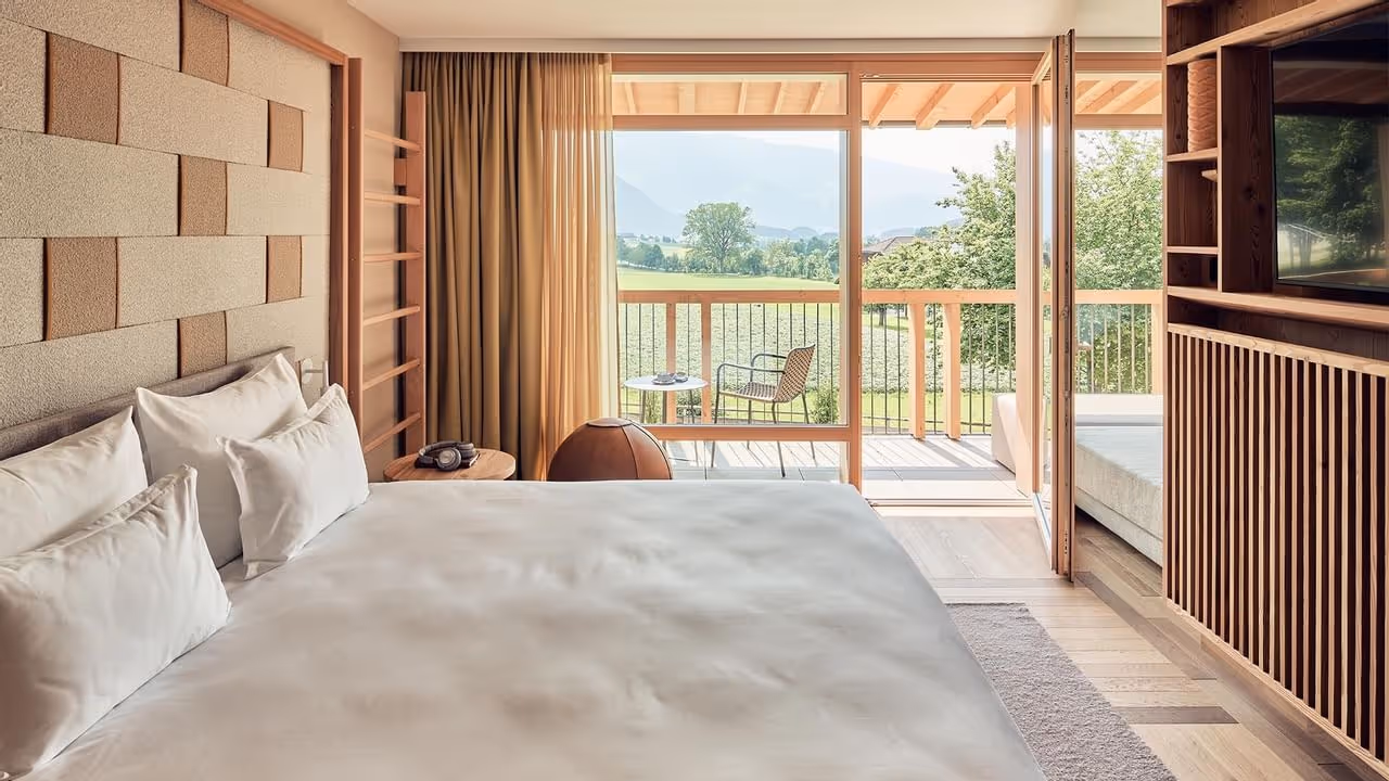 Quarto moderno com cama grande e varanda com vista para o vale
