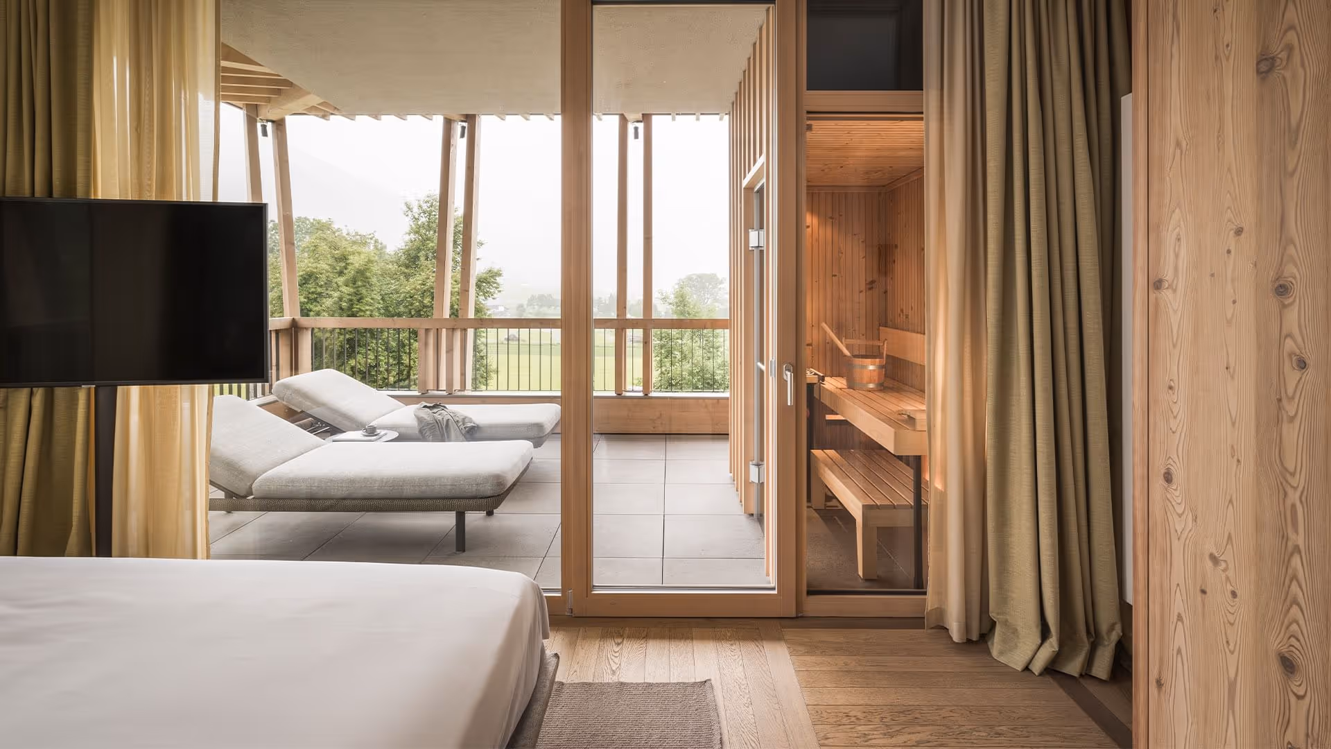 Summit Suite com cama, porta aberta para o terraço com espreguiçadeiras e sauna