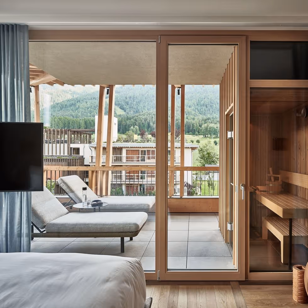 Quarto com varanda e vista para as montanhas através de portas de vidro
