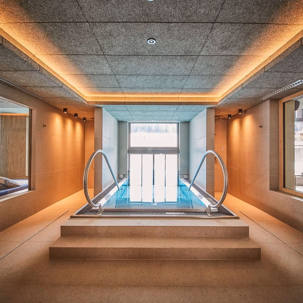 Piscina interna moderna com paredes de vidro no Falkensteiner Hotel Kronplatz
