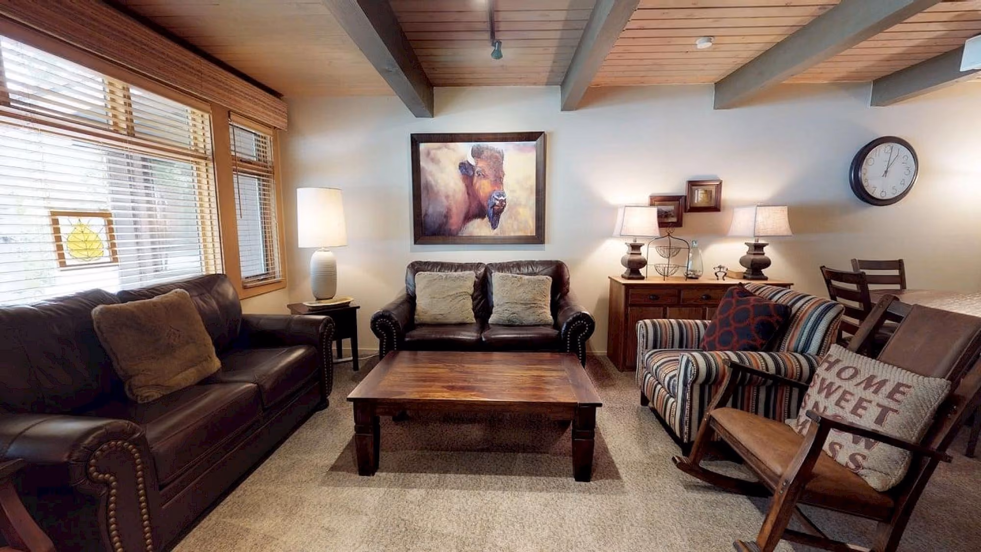 Sala de estar com sofás de couro, mesa de madeira e decoração alpina