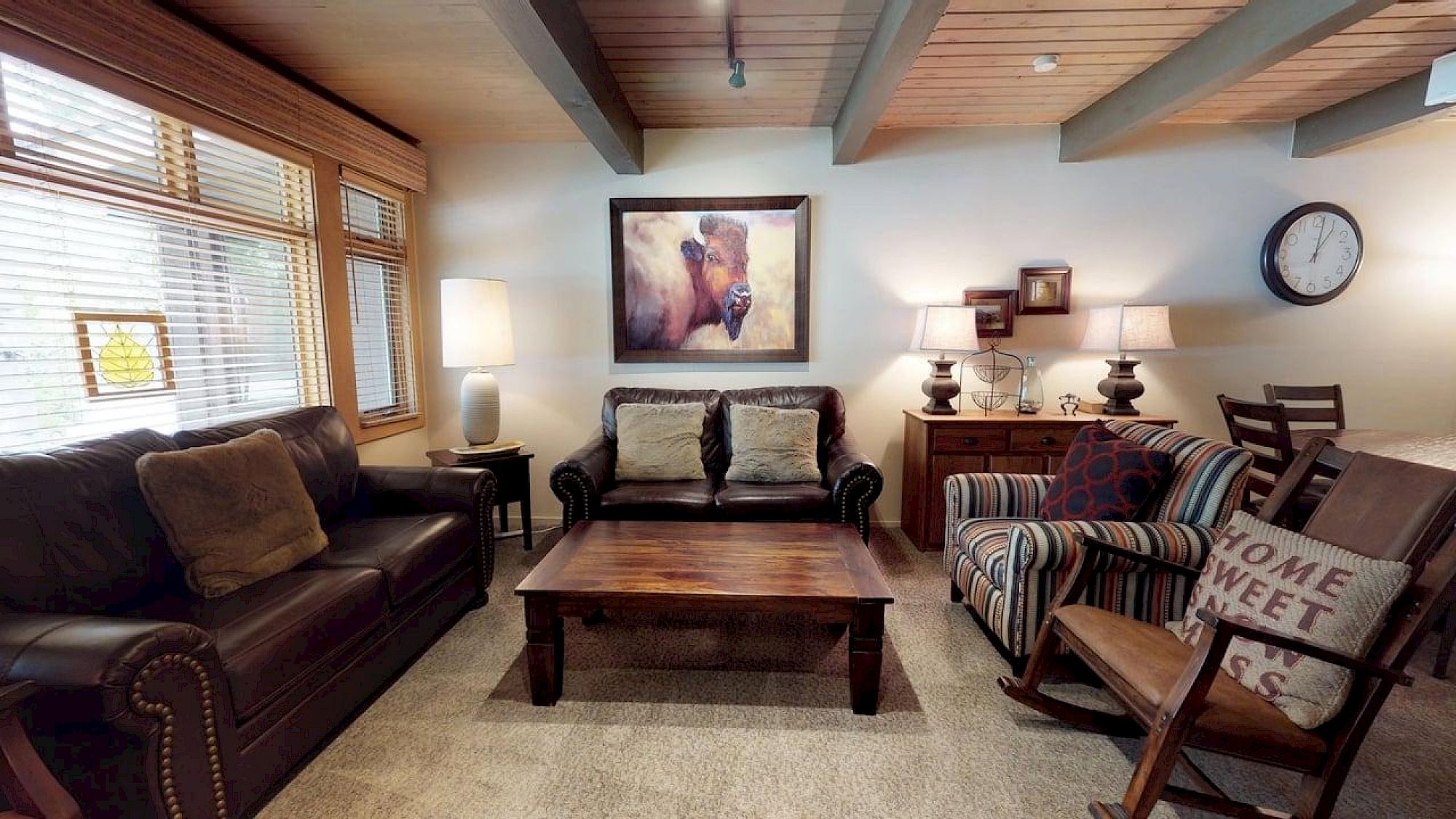 Sala de estar com sofás de couro, mesa de madeira e decoração alpina
