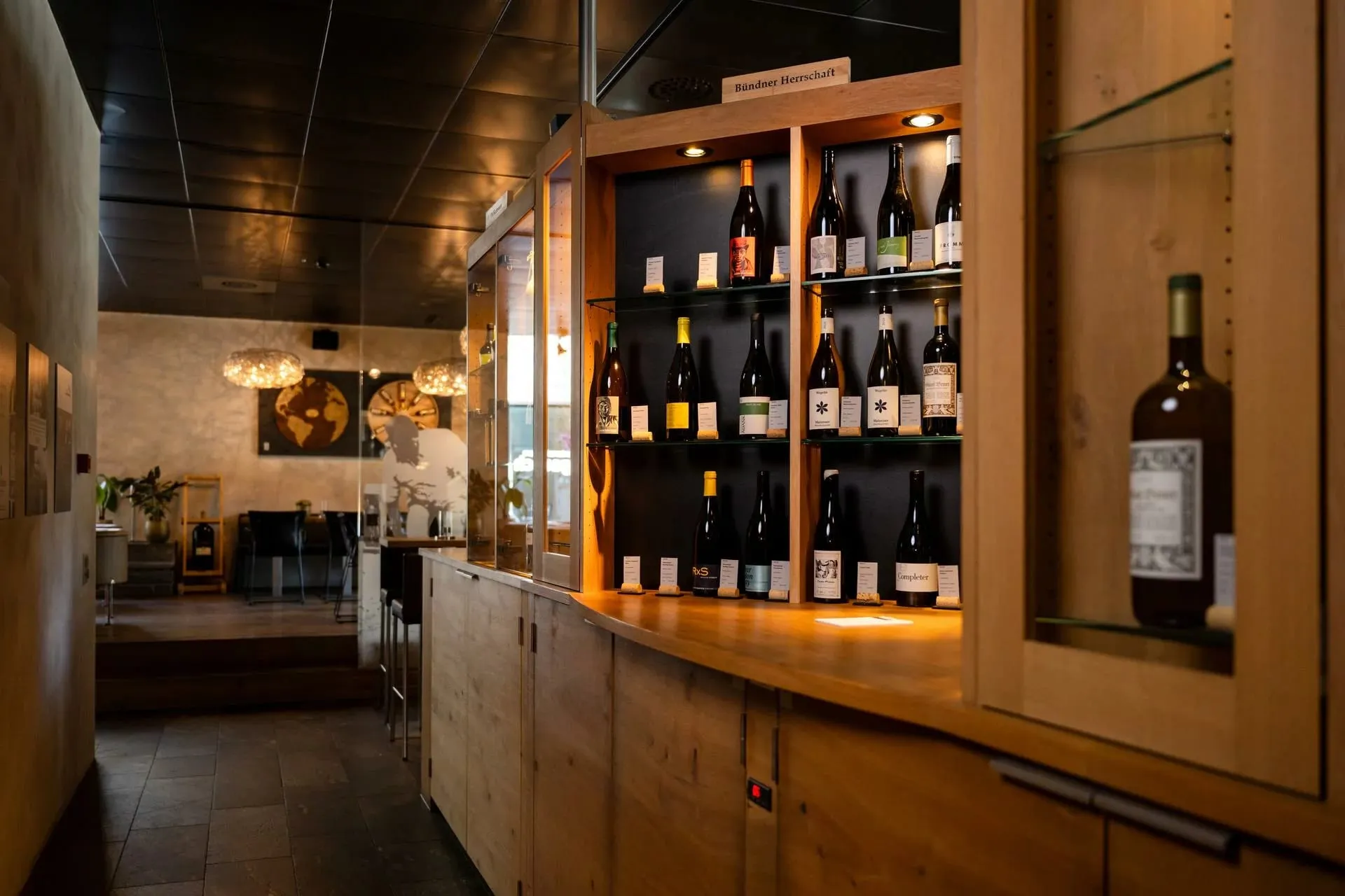 Adega com garrafas de vinho expostas em armário iluminado