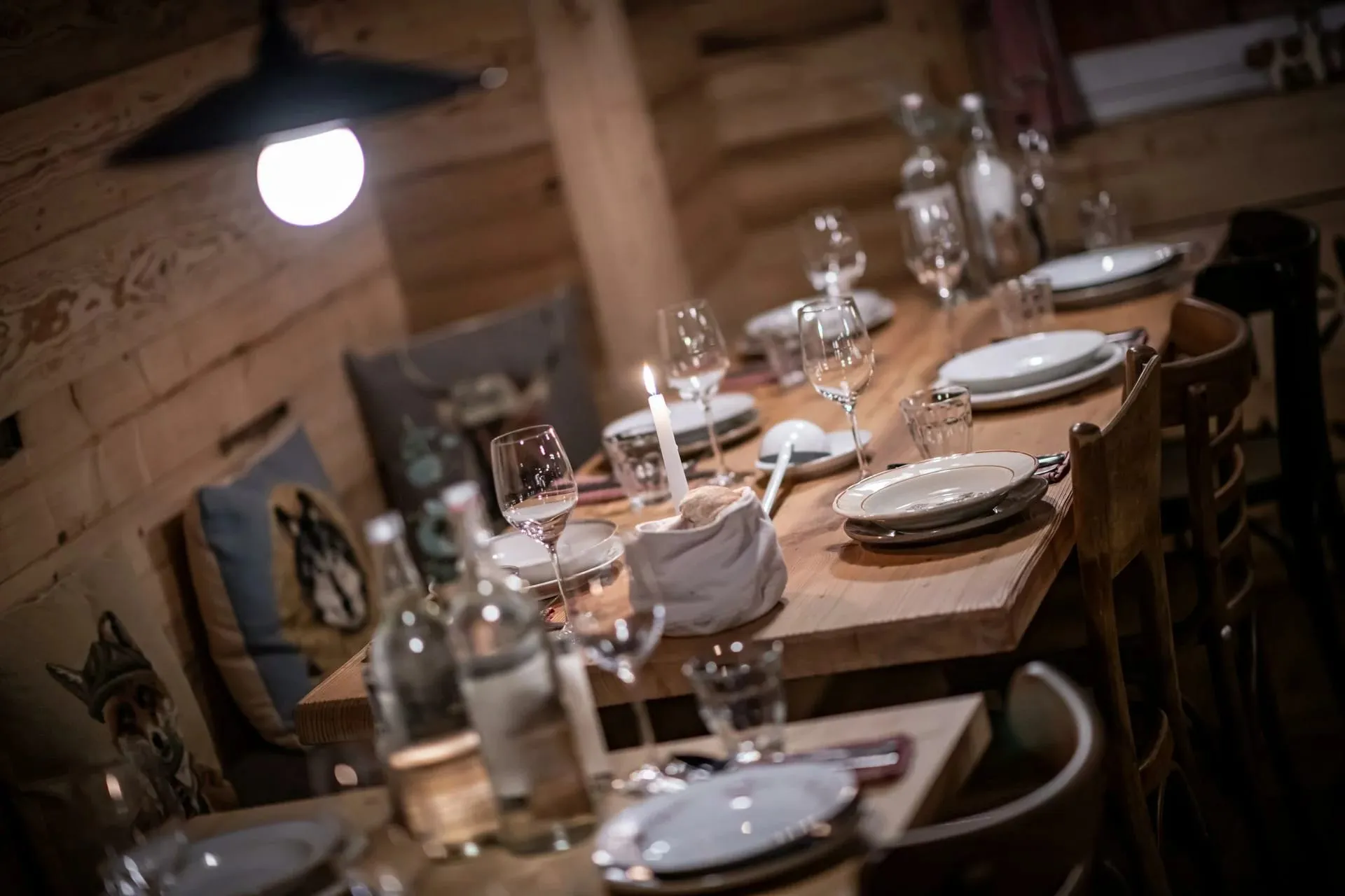 Mesa posta com velas em restaurante rústico de madeira