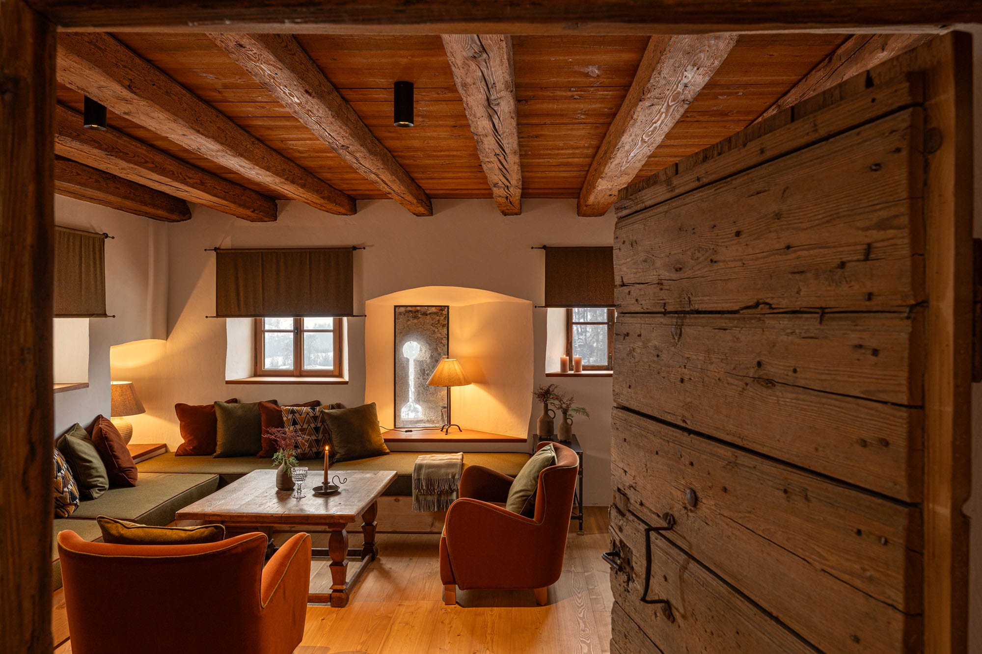 Sala de estar aconchegante com vigas de madeira e sofás coloridos