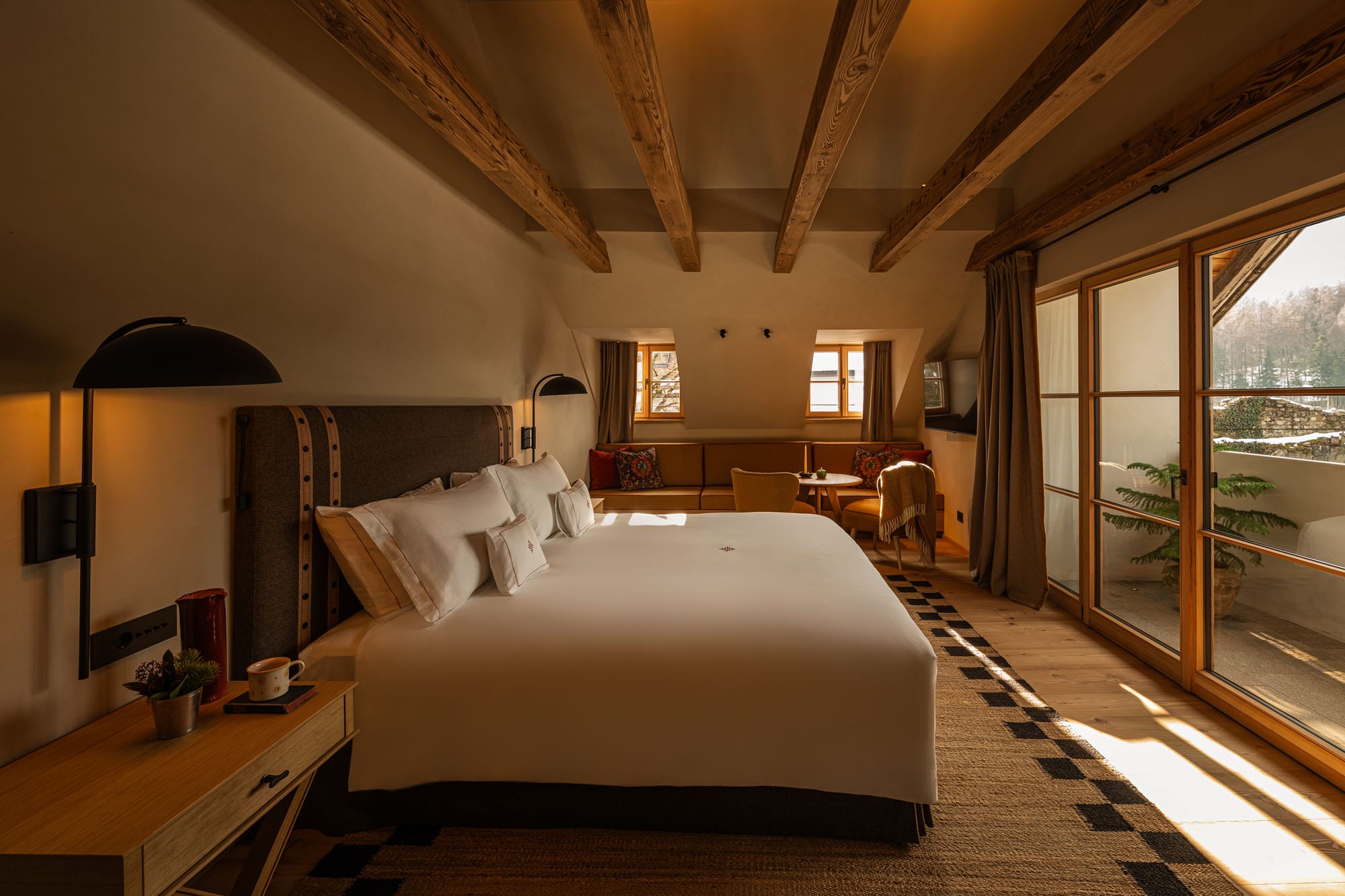 Quarto com cama king-size e varanda envidraçada com vista para neve