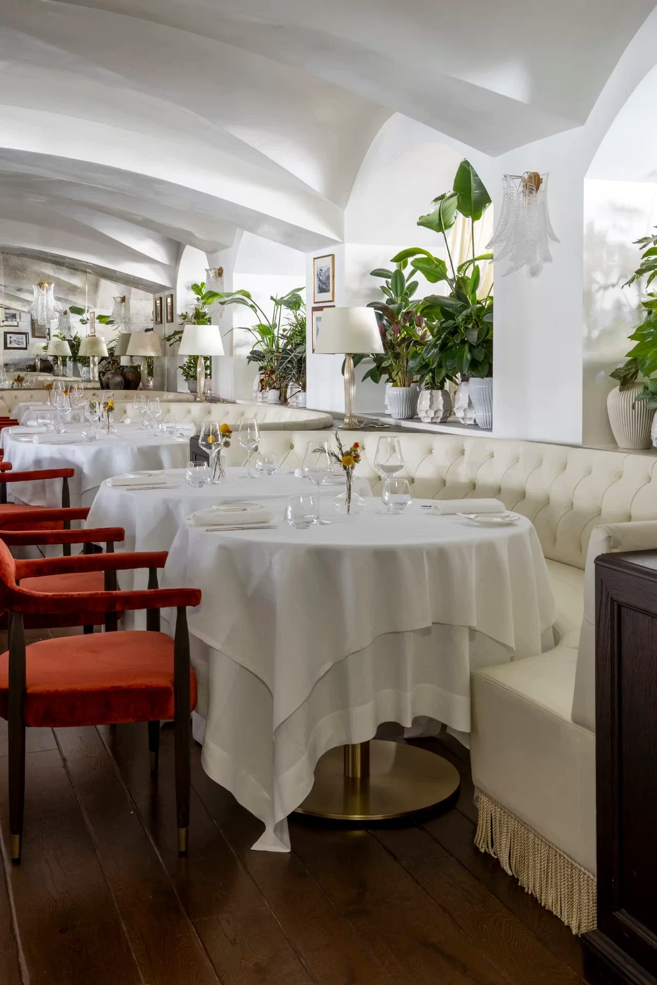 Restaurante elegante com mesas redondas brancas e abóbadas iluminadas