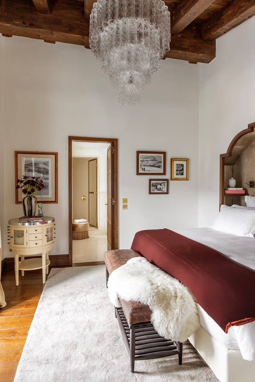 Quarto luminoso com lustre de cristal Murano e vigas de madeira