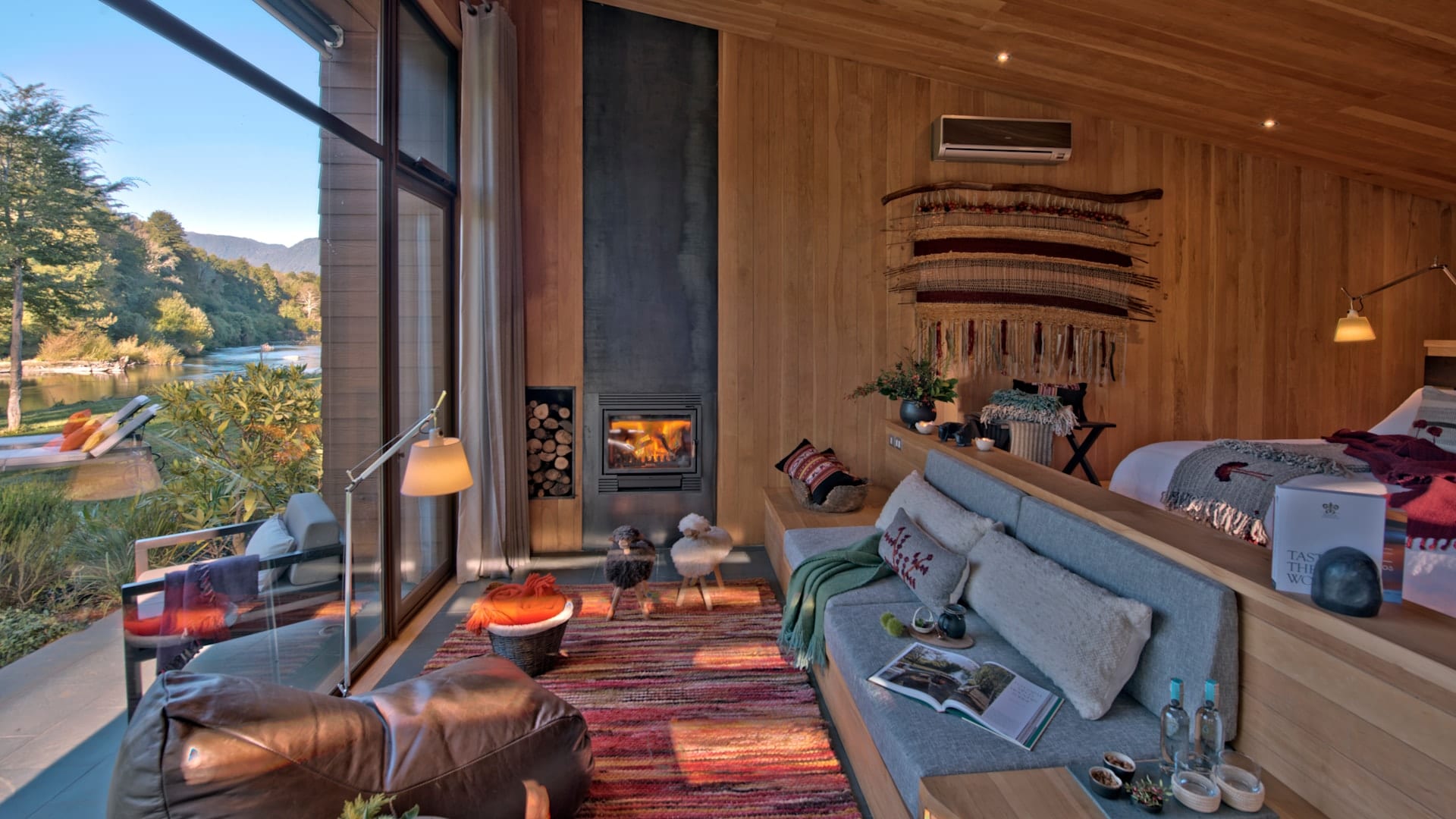 Suite com lareira, sofá e vista panorâmica para o rio Liucura