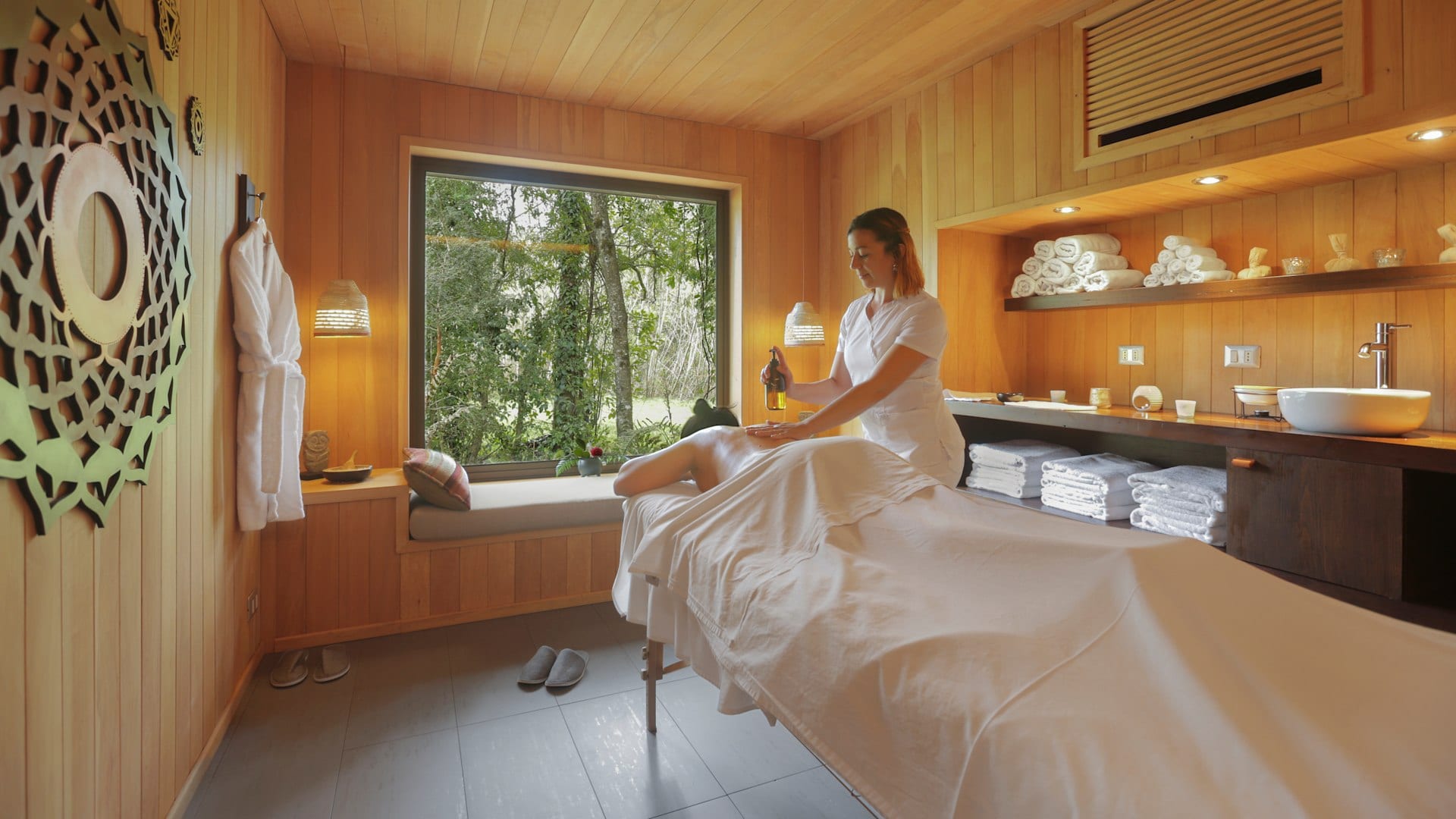 Sala de massagem do spa com terapeuta e decoração em madeira natural