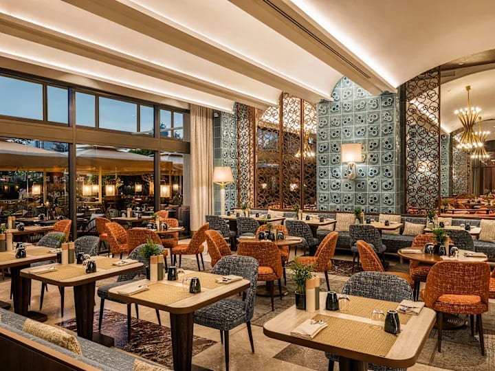 Restaurante amplo com painéis decorativos e cadeiras laranja e cinza