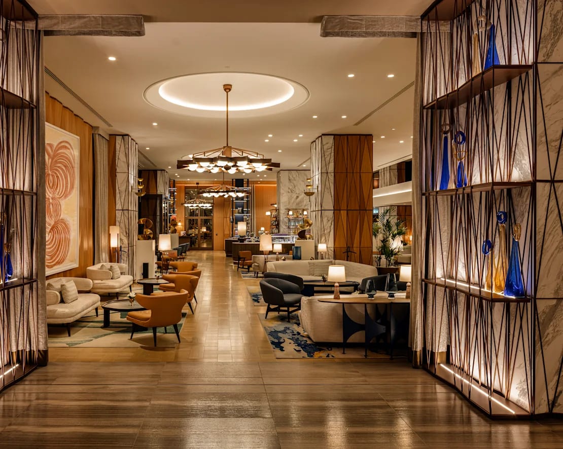 Lobby elegante com iluminação quente e mobiliário contemporâneo