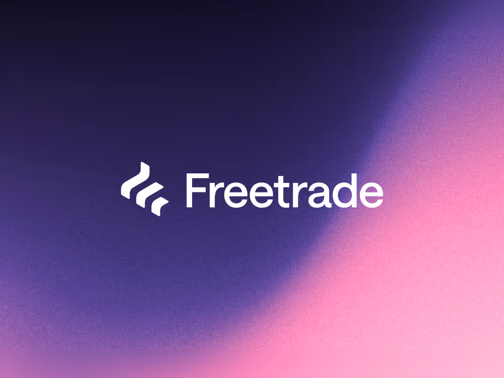 A purple and pink gradient background with a white Freetrade logo in the centre