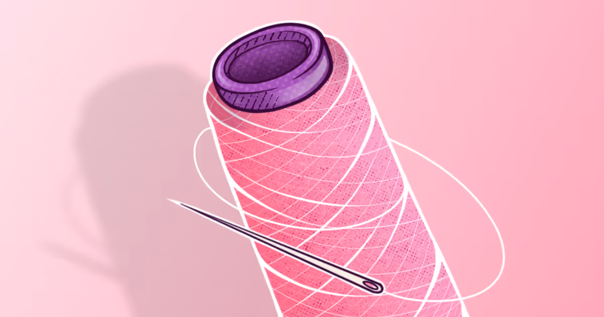 Needle and thread on pink background