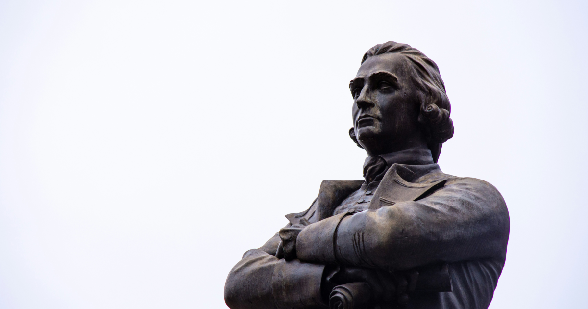 Adam Smith statue, arms crossed, staring into distance