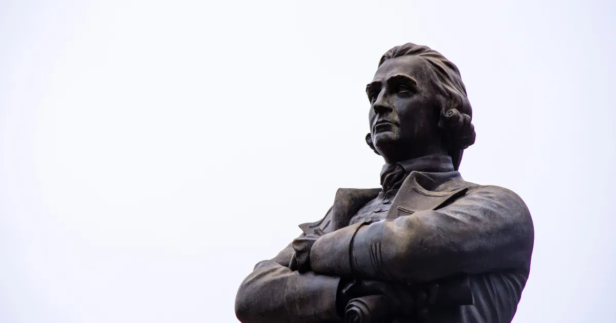Adam Smith statue, arms crossed, staring into distance
