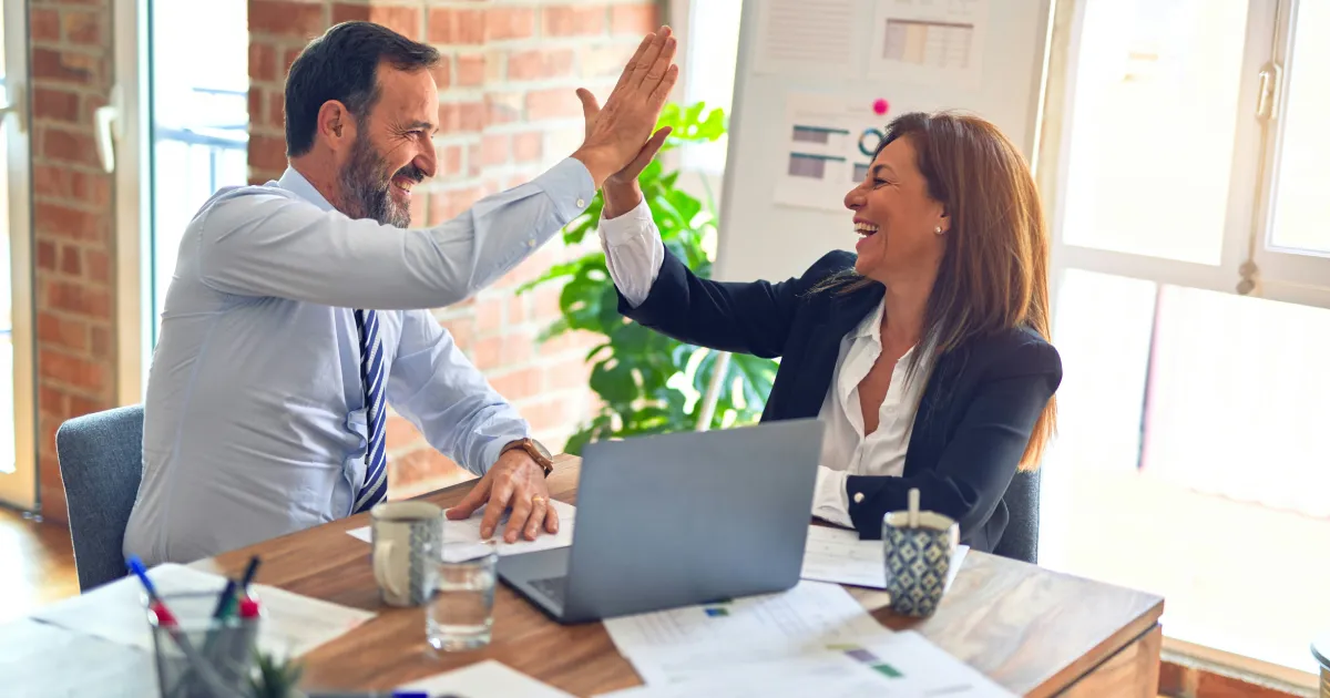Two office workers high fiving