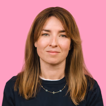 Portrait of Rose, Director of Engineering at Freetrade, on a pink background.