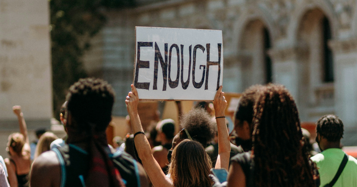 Gen Z protestor holding sing saying 'Enough'