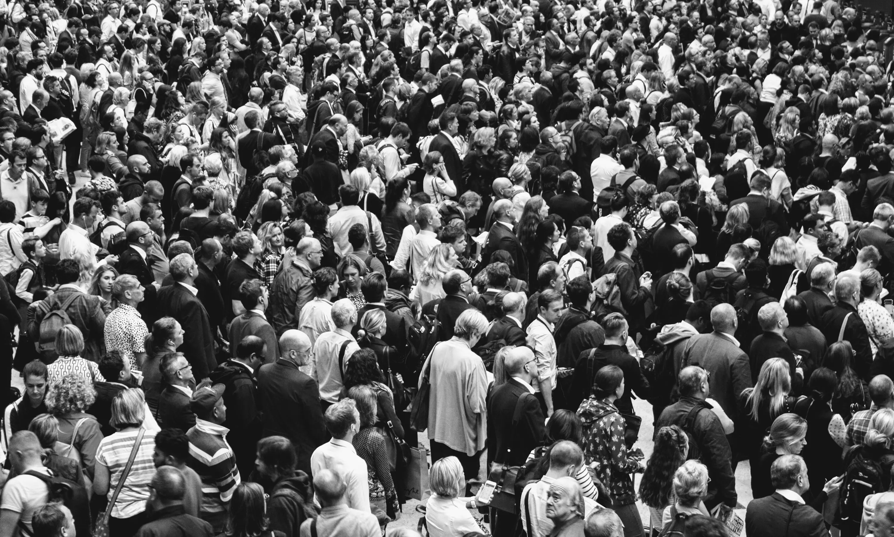 A large crowd of people seen from above, in black and white