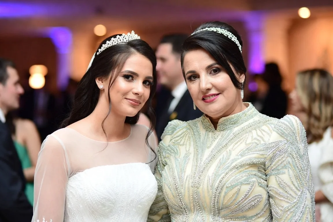 Bride posing with her mother at the wedding reception, representing a mother of the bride gift idea